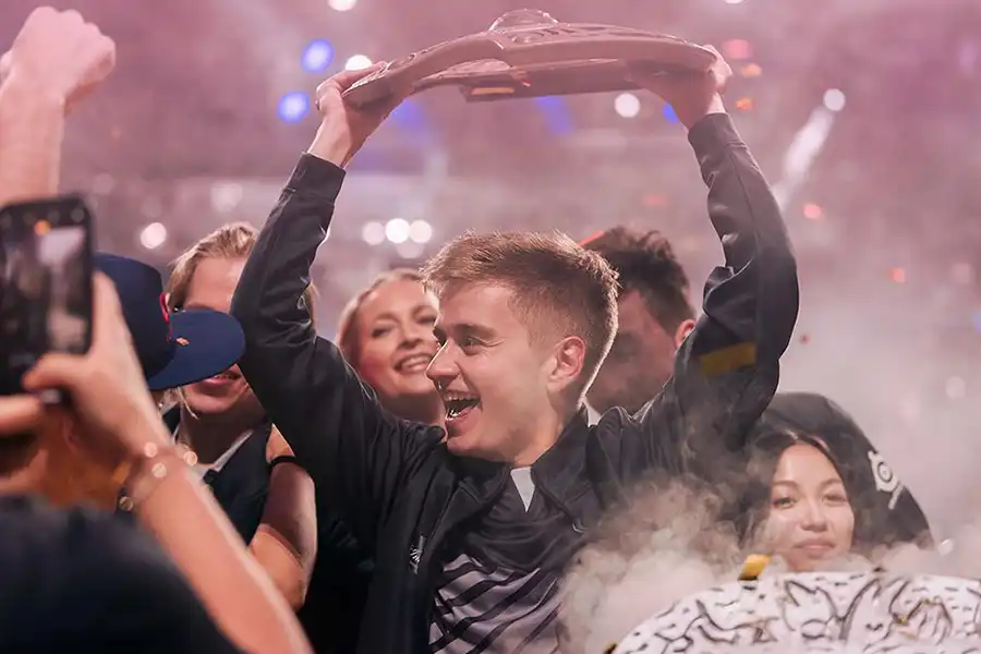 Image of a player holding the prize over his head for winning the tournament.