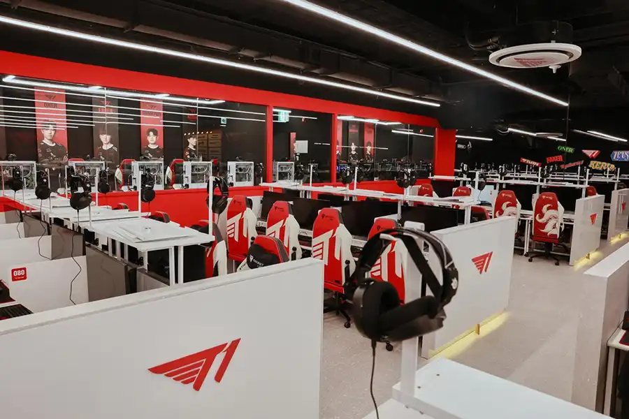 a modern esports training facility with red-themed decor and individual gaming stations.