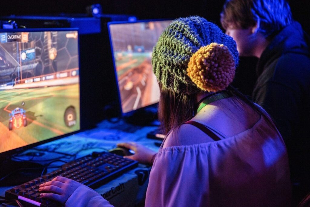 picture of a female player behind her gaming system.