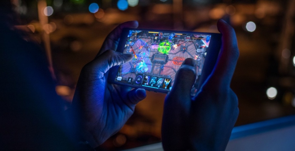 a picture of a gamer playing games with a smartphone