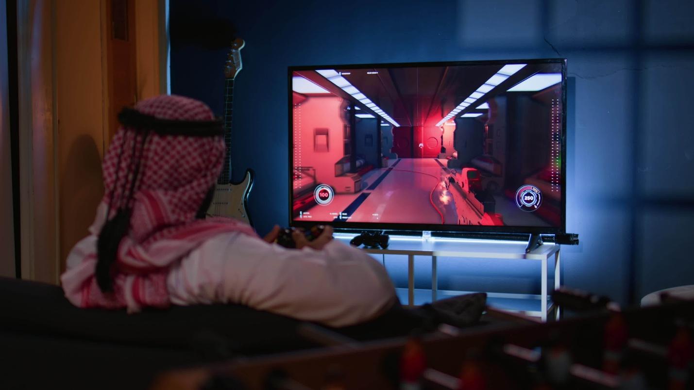 a picture of an Arabian man playing a video game.