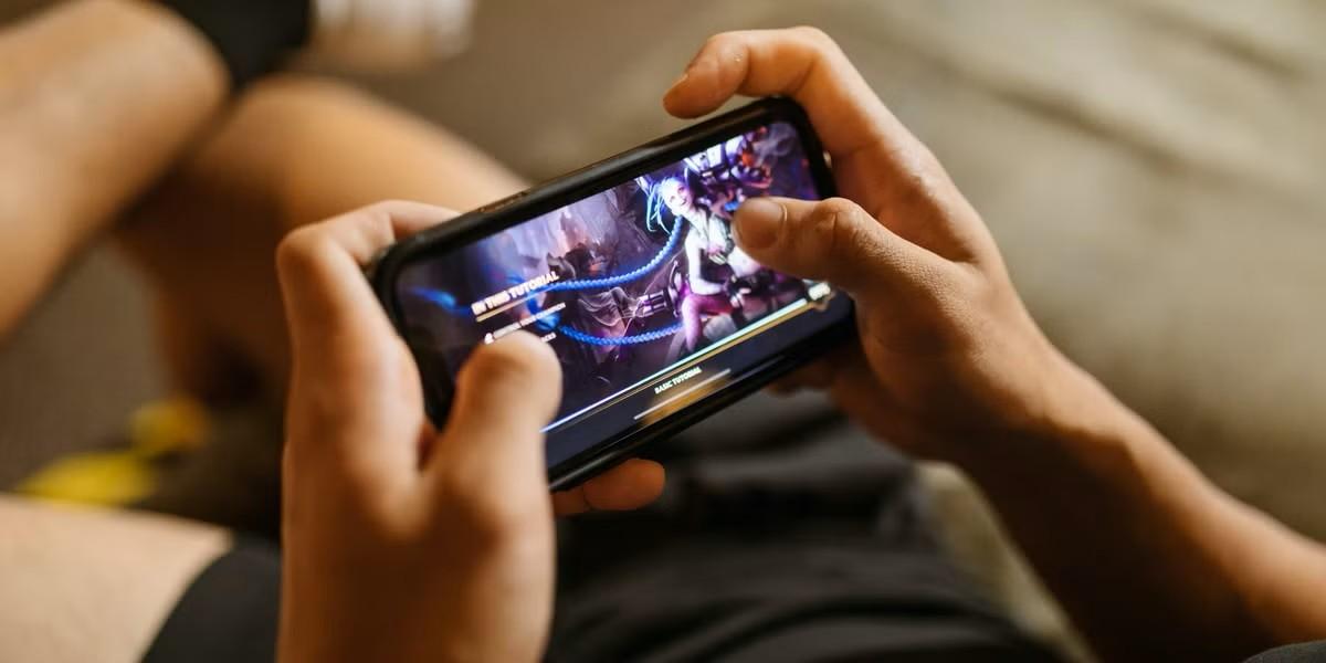 a man playing video games with his smartphone.
