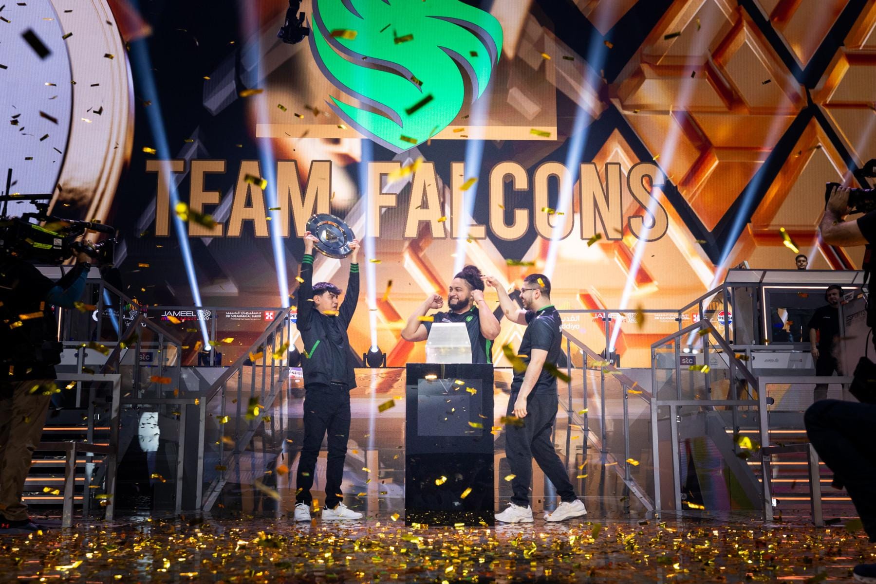 a picture of Team Falcons holding a trophy.