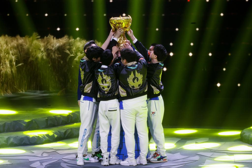 an image of an ESports Team holding a trophy. 