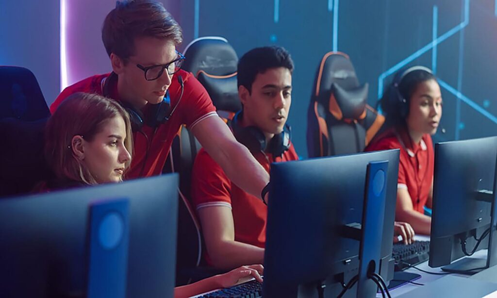an image of an Esports team while the coach is guiding them