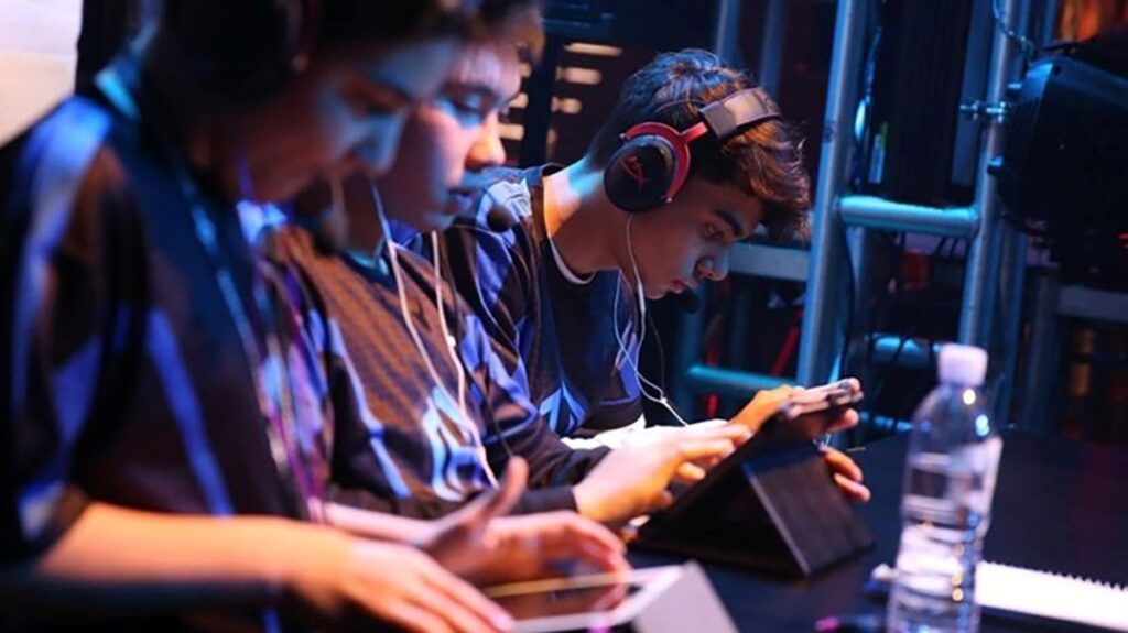 an image of players in an ESports Tournament playing with their smartphones
